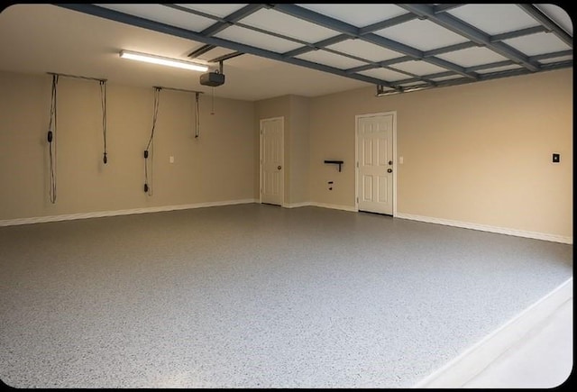 garage with baseboards and a garage door opener