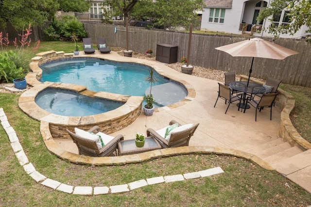 view of swimming pool featuring a patio area, a fenced backyard, a pool with connected hot tub, and outdoor dining area