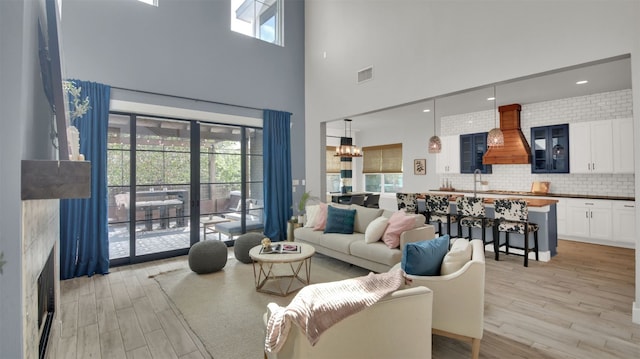1506 Fox Sparrow Trl, Cedar Park, TX 78613 - living area with a towering ceiling, light wood-type flooring, and a chandelier