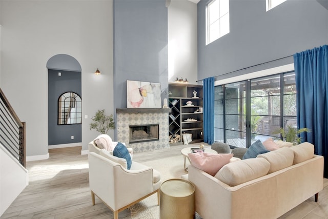 1506 Fox Sparrow Trl, Cedar Park, TX 78613 - living room featuring a towering ceiling, wood finished floors, a tiled fireplace, and baseboards
