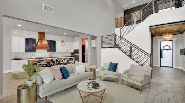 1506 Fox Sparrow Trl, Cedar Park, TX 78613 - living area featuring baseboards, light wood finished floors, a high ceiling, recessed lighting, and stairs