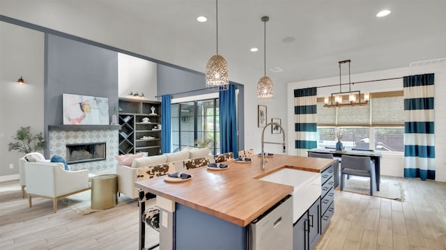 1506 Fox Sparrow Trl, Cedar Park, TX 78613 - kitchen with wooden counters, a chandelier, a sink, light wood finished floors, and decorative light fixtures