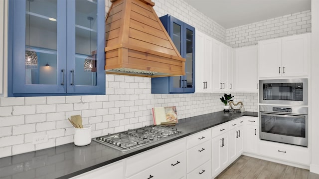 1506 Fox Sparrow Trl, Cedar Park, TX 78613 - kitchen with appliances with stainless steel finishes, premium range hood, dark countertops, glass insert cabinets, and backsplash