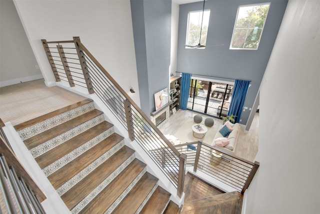 1506 Fox Sparrow Trl, Cedar Park, TX 78613 - stairs with a towering ceiling, baseboards, and wood finished floors