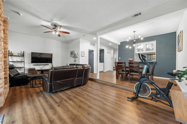 living room with a ceiling fan, wood finished floors, a textured ceiling, baseboards, and recessed lighting