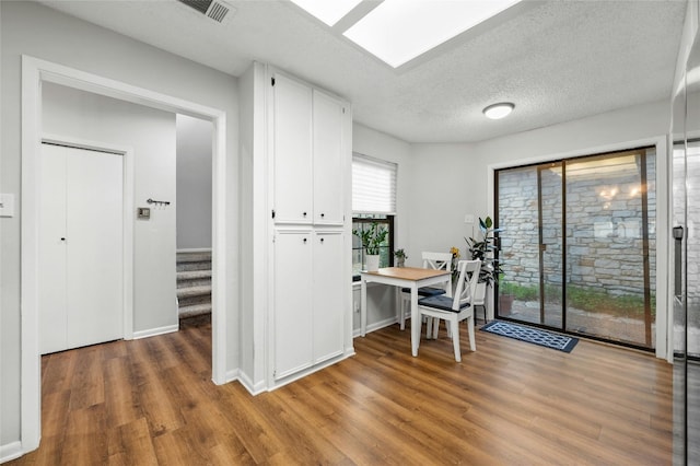 office with light wood-type flooring, a textured ceiling, and baseboards