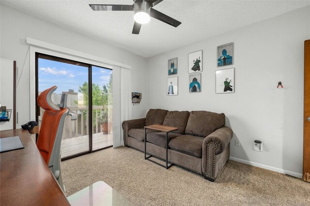 living area featuring a ceiling fan, carpet floors, baseboards, and a textured ceiling