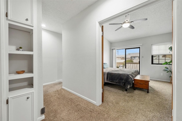 carpeted bedroom featuring a textured ceiling, baseboards, access to exterior, and a ceiling fan