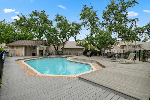 view of swimming pool with fence, a wooden deck, and a patio area