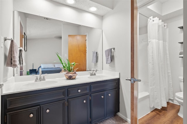 bathroom with toilet, double vanity, shower / bath combination with curtain, and wood finished floors