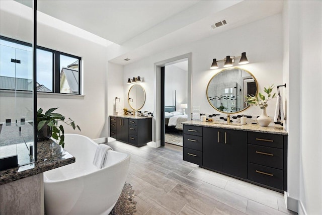 81 Applehead Island Dr, Horseshoe Bay, TX 78657 - ensuite bathroom with a freestanding bath, two vanities, and baseboards