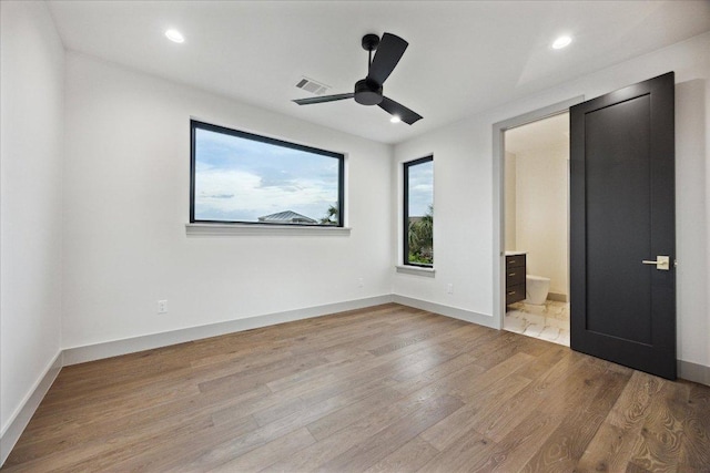 81 Applehead Island Dr, Horseshoe Bay, TX 78657 - unfurnished bedroom featuring light wood-type flooring, baseboards, ensuite bathroom, recessed lighting, and a ceiling fan