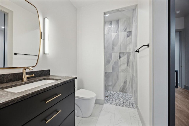 81 Applehead Island Dr, Horseshoe Bay, TX 78657 - bathroom featuring marble finish flooring, toilet, tiled shower, vanity, and baseboards