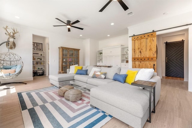 705 Highland Overlook, Georgetown, TX 78633 - living room with ceiling fan, a barn door, recessed lighting, light wood-style flooring, and baseboards