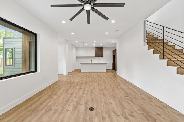4407 Merle Dr Unit A, Austin, TX 78745 - unfurnished living room with light wood-style flooring, baseboards, stairway, a ceiling fan, and recessed lighting