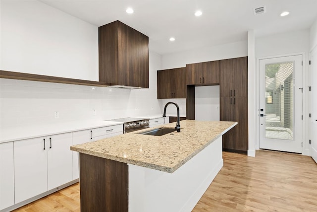 4407 Merle Dr Unit A, Austin, TX 78745 - kitchen with a sink, light wood finished floors, modern cabinets, dark brown cabinetry, and recessed lighting