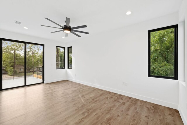 4407 Merle Dr Unit A, Austin, TX 78745 - empty room with plenty of natural light, a ceiling fan, light wood-style floors, baseboards, and recessed lighting