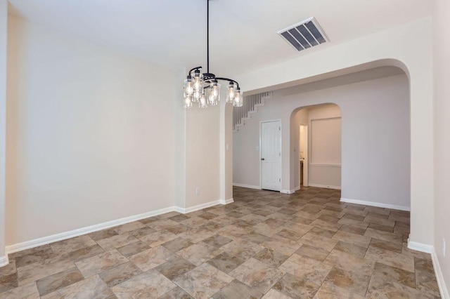 409 S Frontier Ln, Cedar Park, TX 78613 - unfurnished room featuring arched walkways, a chandelier, stone finish flooring, and baseboards