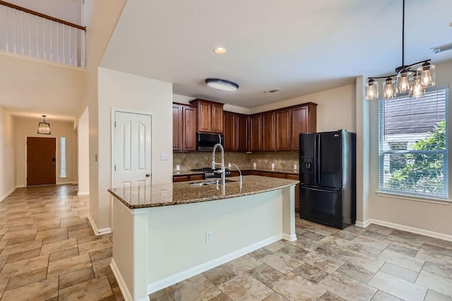 409 S Frontier Ln, Cedar Park, TX 78613 - kitchen featuring black appliances, dark stone counters, backsplash, a chandelier, and stone finish floors