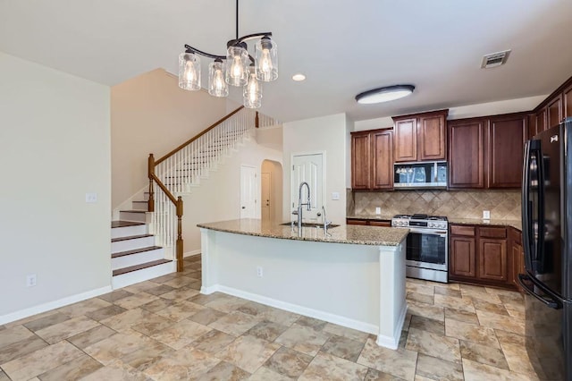 409 S Frontier Ln, Cedar Park, TX 78613 - kitchen with stainless steel appliances, a sink, tasteful backsplash, light stone countertops, and arched walkways