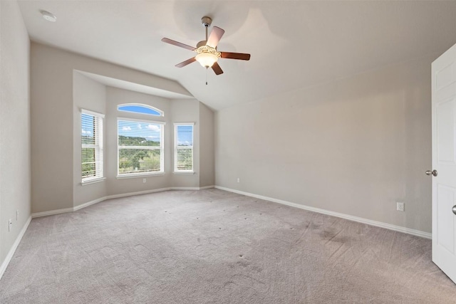 carpeted spare room with lofted ceiling, baseboards, and ceiling fan