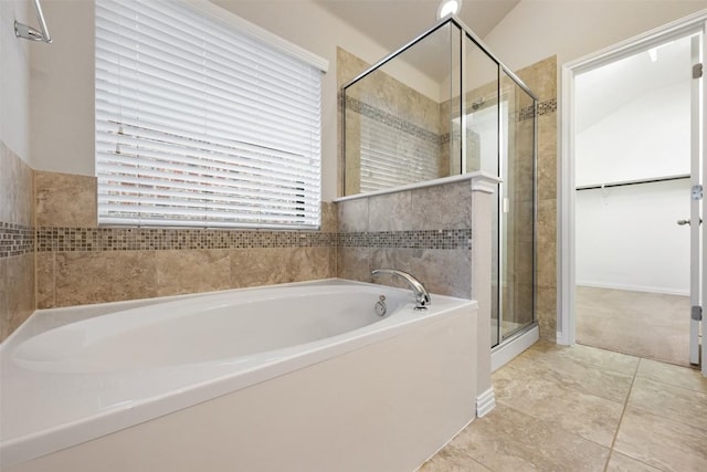 full bath featuring a shower stall, a bath, a spacious closet, and tile patterned flooring