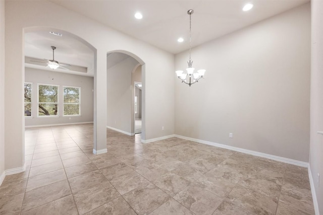 unfurnished dining area featuring arched walkways, ceiling fan, recessed lighting, baseboards, and a chandelier