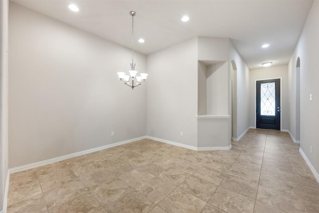 foyer featuring arched walkways, a chandelier, recessed lighting, and baseboards