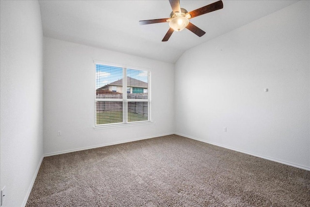carpeted spare room featuring ceiling fan, vaulted ceiling, and baseboards