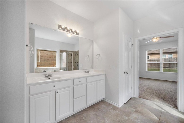 bathroom with a shower stall, double vanity, a ceiling fan, baseboards, and tile patterned floors