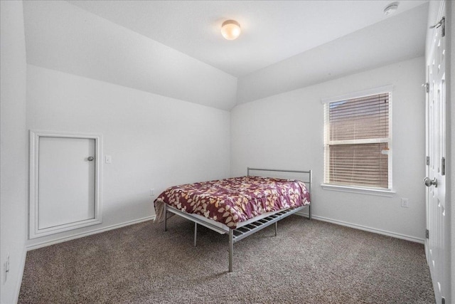 bedroom with carpet flooring, vaulted ceiling, and baseboards