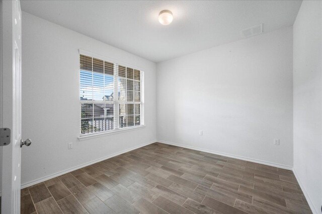 empty room featuring wood tiled floors and baseboards