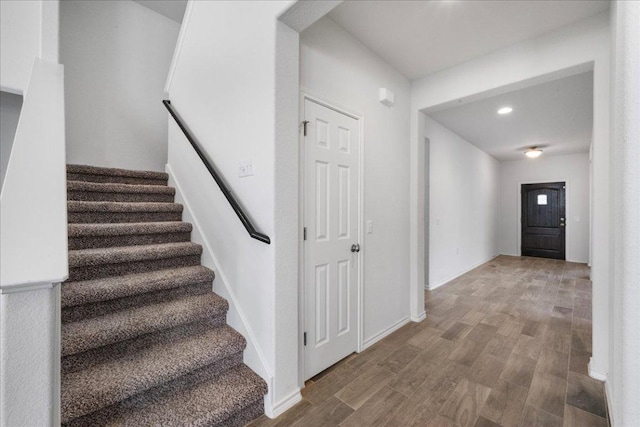 staircase with wood finished floors and baseboards