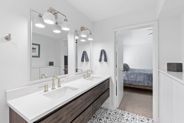 ensuite bathroom featuring double vanity and tile patterned floors