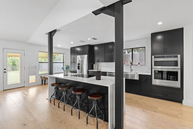 3305 Eldorado Trl, Austin, TX 78748 - kitchen with stainless steel appliances, dark cabinetry, light wood-type flooring, and recessed lighting