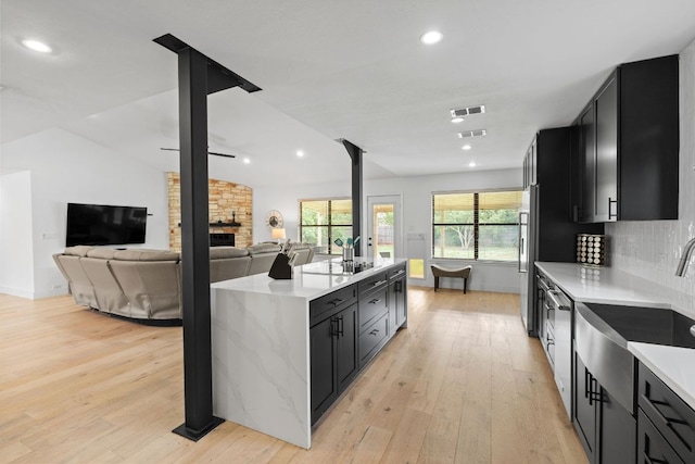 3305 Eldorado Trl, Austin, TX 78748 - kitchen featuring dark cabinets, light wood-type flooring, a sink, recessed lighting, and lofted ceiling
