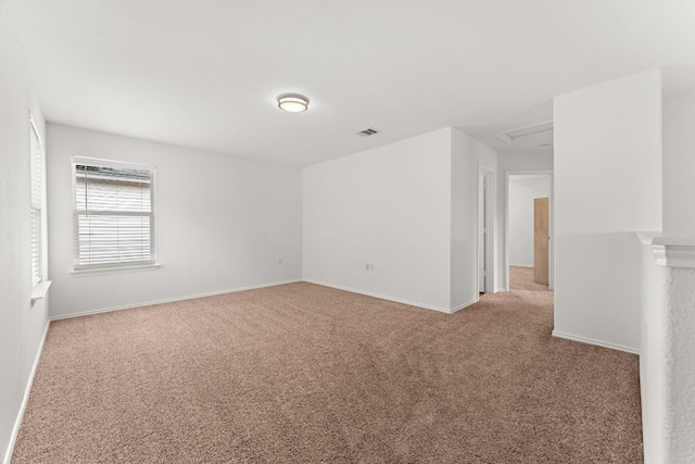 spare room with carpet floors, baseboards, and attic access