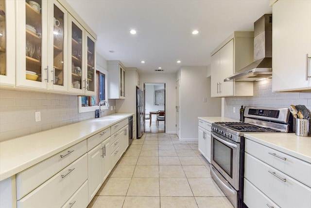 3409 Sanderling Trl, Austin, TX 78746 - kitchen featuring stainless steel gas range oven, wall chimney range hood, decorative backsplash, a sink, and light countertops