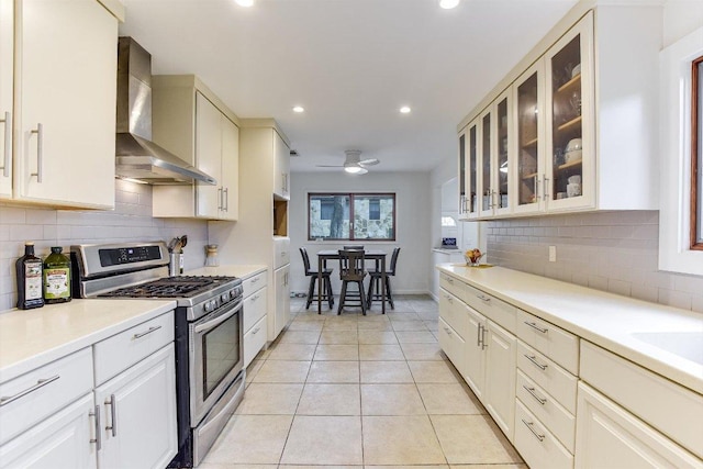 3409 Sanderling Trl, Austin, TX 78746 - kitchen with stainless steel gas range oven, wall chimney exhaust hood, decorative backsplash, light countertops, and recessed lighting