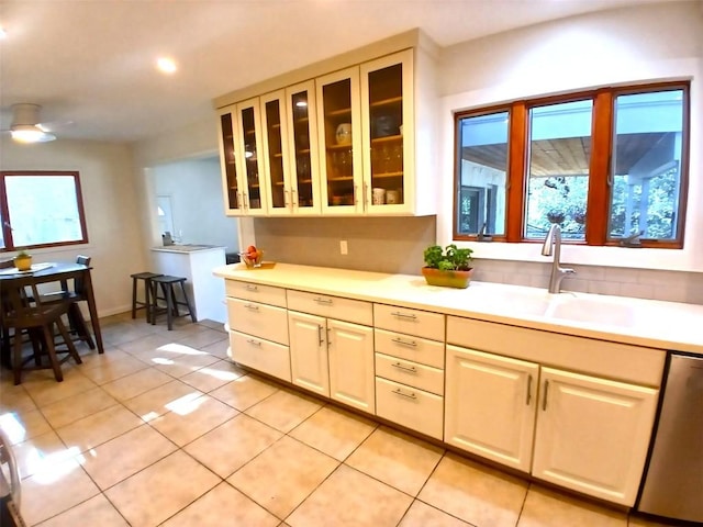 3409 Sanderling Trl, Austin, TX 78746 - kitchen with dishwasher, light countertops, glass insert cabinets, light tile patterned floors, and a sink