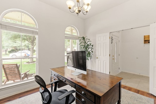 office area featuring a chandelier, wood finished floors, and baseboards