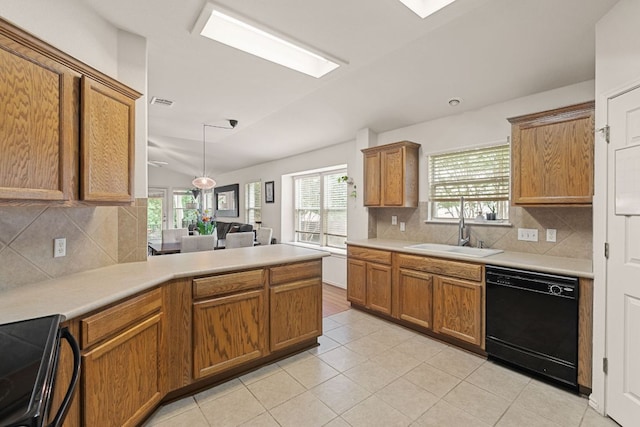 kitchen featuring black appliances, a sink, brown cabinetry, decorative backsplash, and a peninsula