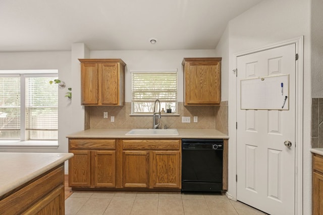 kitchen with black dishwasher, a sink, light countertops, and plenty of natural light