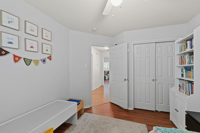 sitting room with dark wood finished floors and a ceiling fan