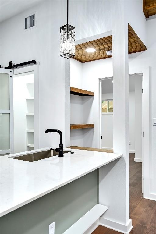1006 Cherico St, Austin, TX 78702 - kitchen with dark wood-type flooring, light countertops, decorative light fixtures, and open shelves