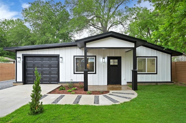 1006 Cherico St, Austin, TX 78702 - view of front facade with board and batten siding, an attached garage, and driveway
