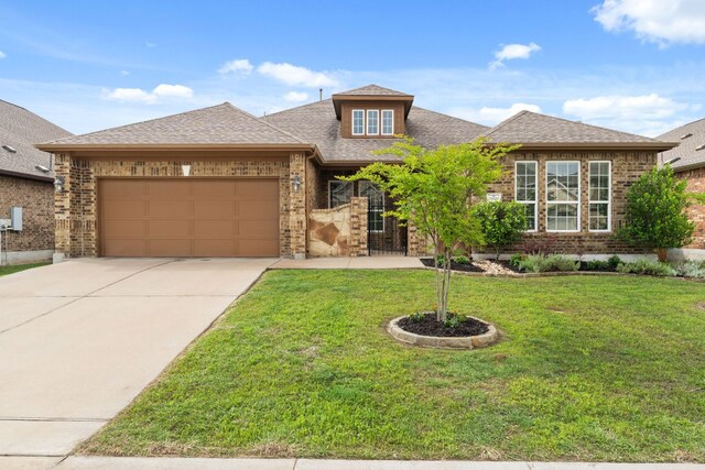 view of front of house with brick siding, an attached garage, concrete driveway, and a front lawn