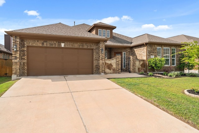 view of front of home with brick siding, concrete driveway, a front yard, and an attached garage