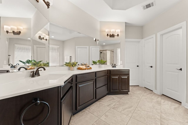 bathroom with a shower stall and double vanity
