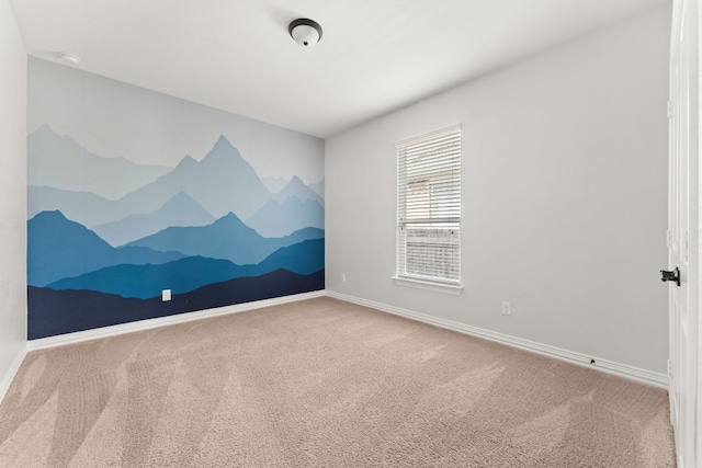 spare room featuring carpet flooring, baseboards, and a smoke detector
